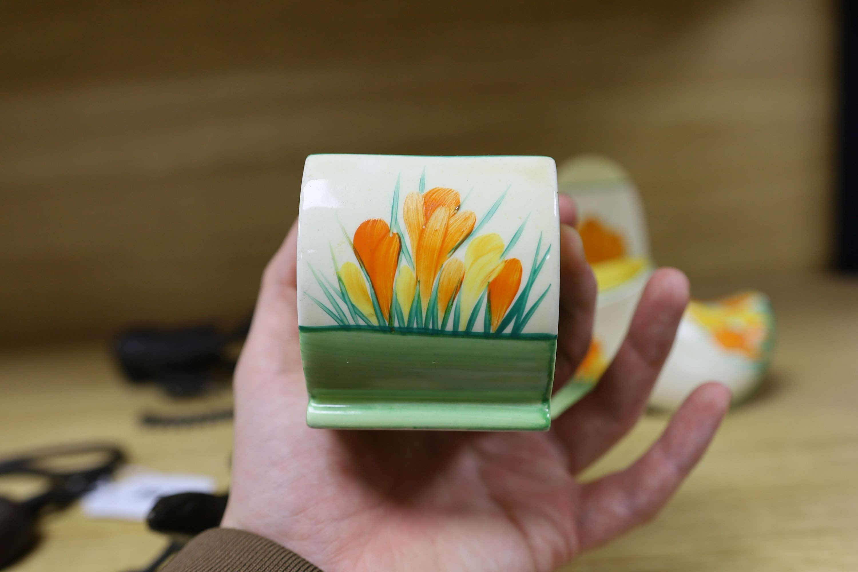 A Clarice Cliff sungleam crocus jam pot and cover, a sugar shaker and a Dutch clog ornament (3), jam pot and cover 10 cms high
